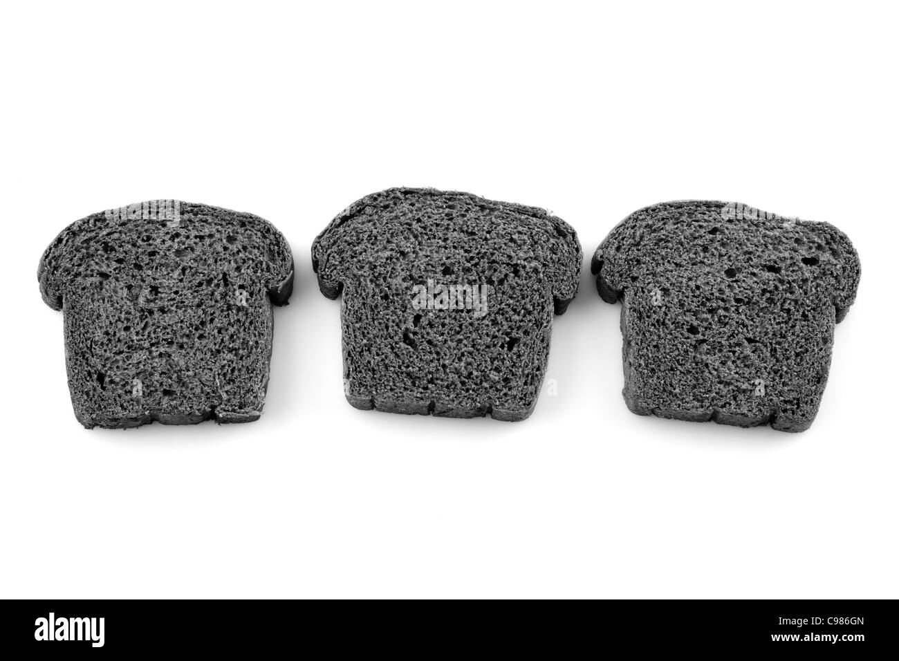 Trois tranches de pain de charbon noir sur fond blanc Banque D'Images