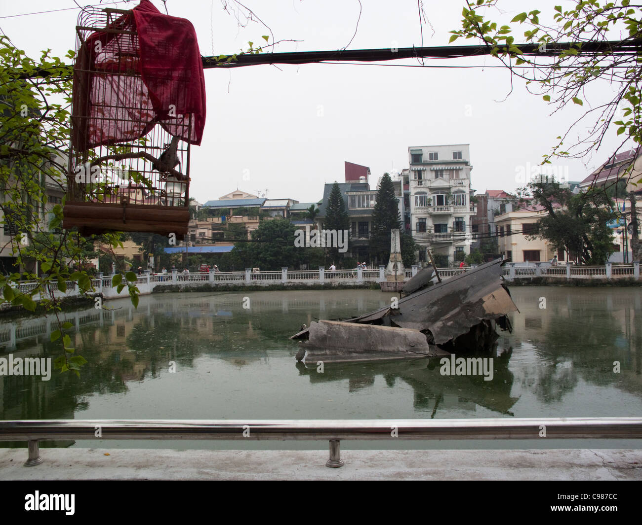 Bird Cage suspendue au-dessus du B52 bomber épave dans Huu Tiep lake, Hanoi, Vietnam Banque D'Images