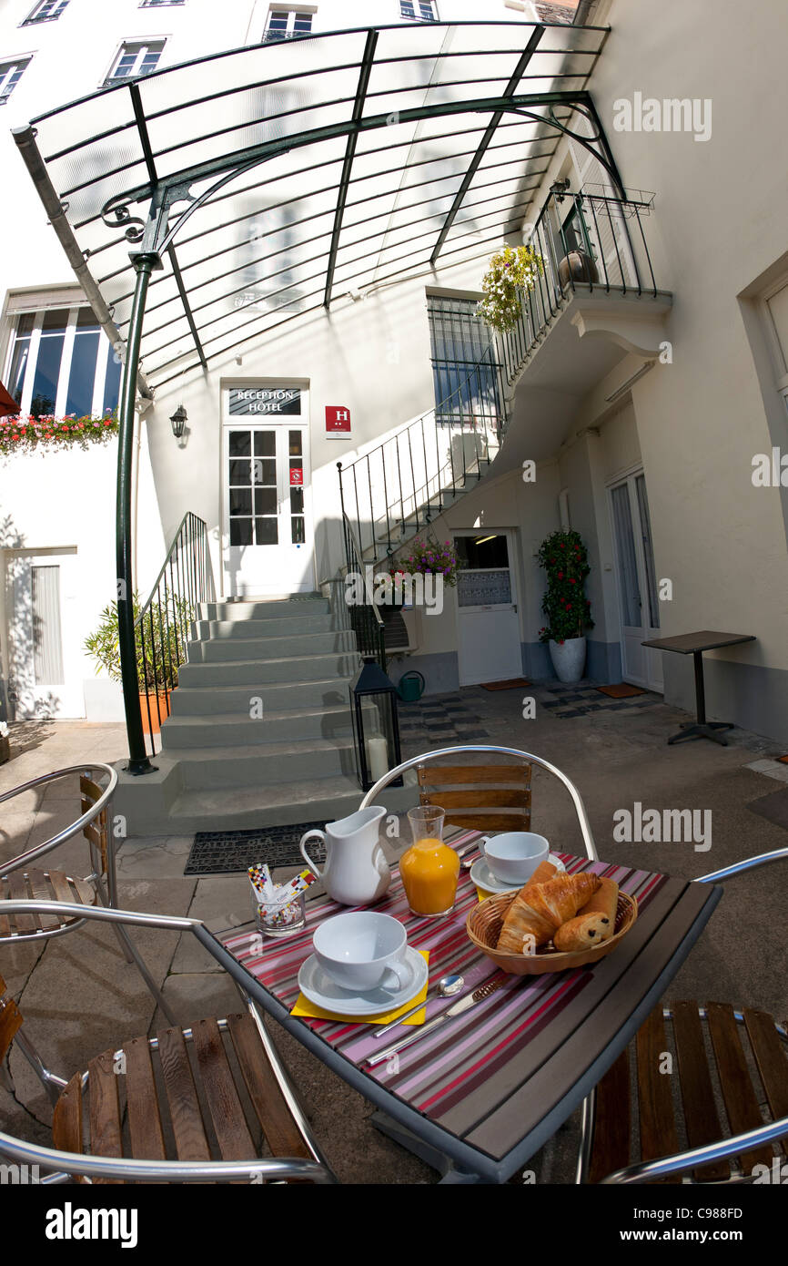 Un petit-déjeuner servi à l'extérieur, dans une cour de l'hôtel de tourisme (France). Petit-déjeuner servi en extérieur dans une cour d'hôtel. Banque D'Images
