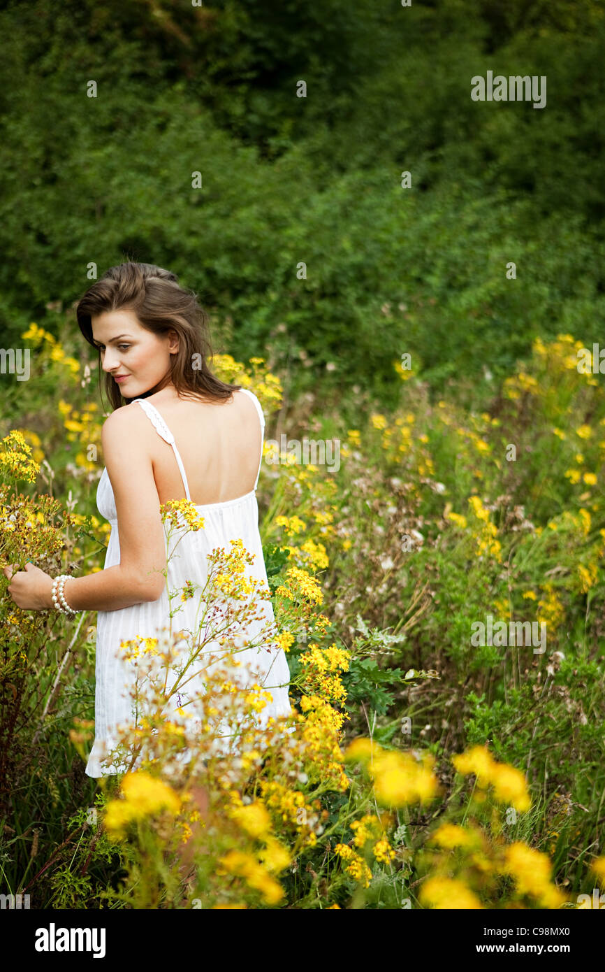 Young Woman picking flowers campagne Banque D'Images