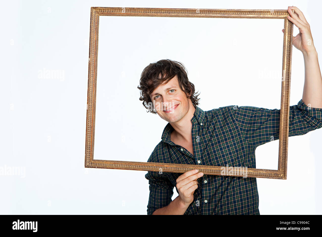 Mid adult man holding photo frame against white background Banque D'Images