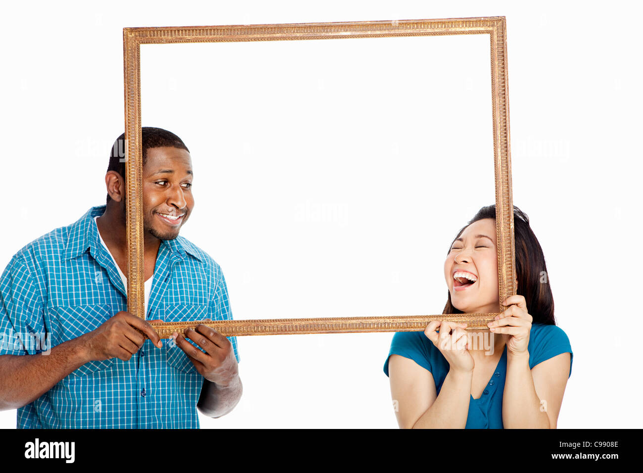 Mixed Race woman holding photo frame against white background Banque D'Images