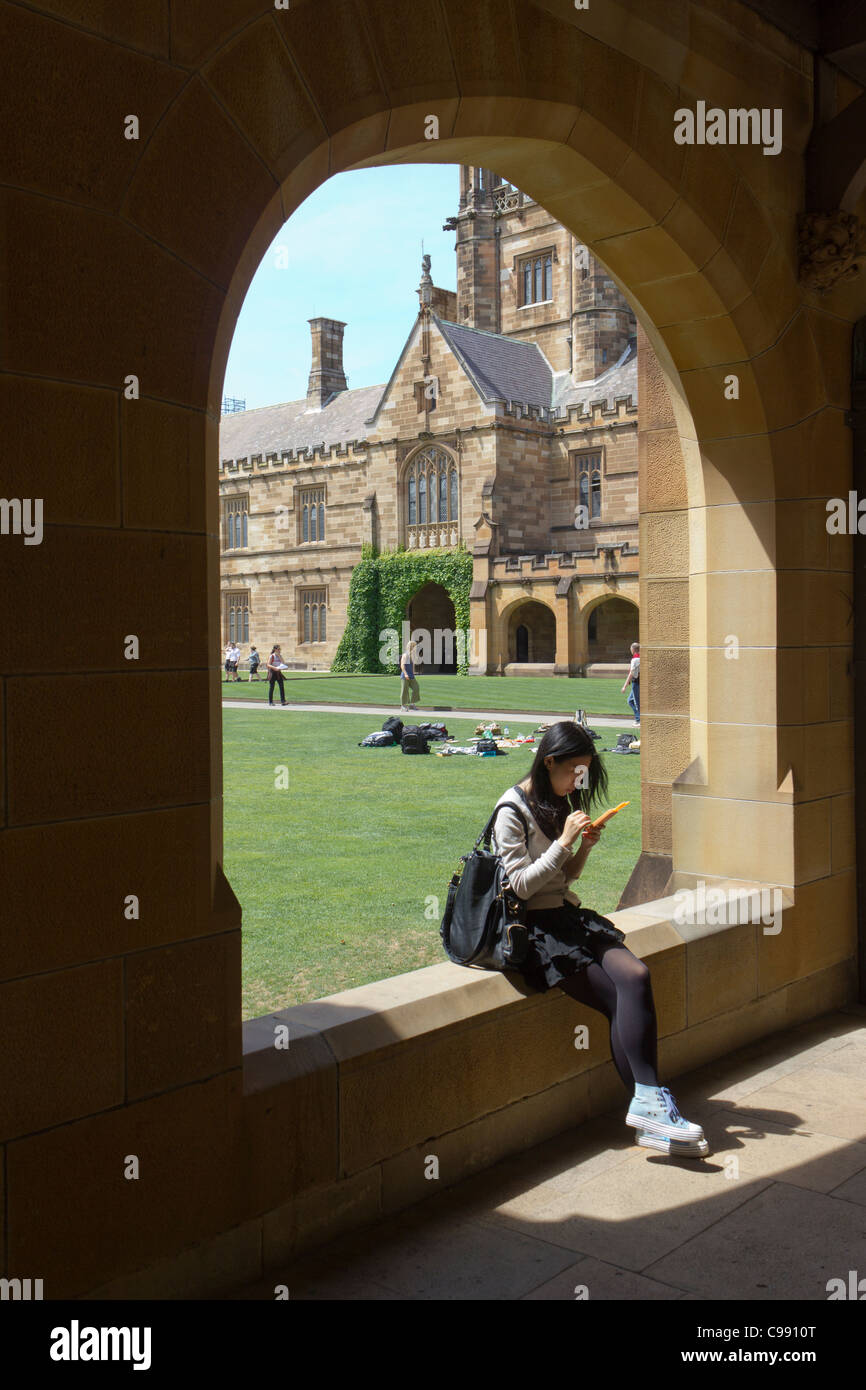Asian student sitting on wall, Université de Sydney main quadrangle, Sydney, Australie Banque D'Images