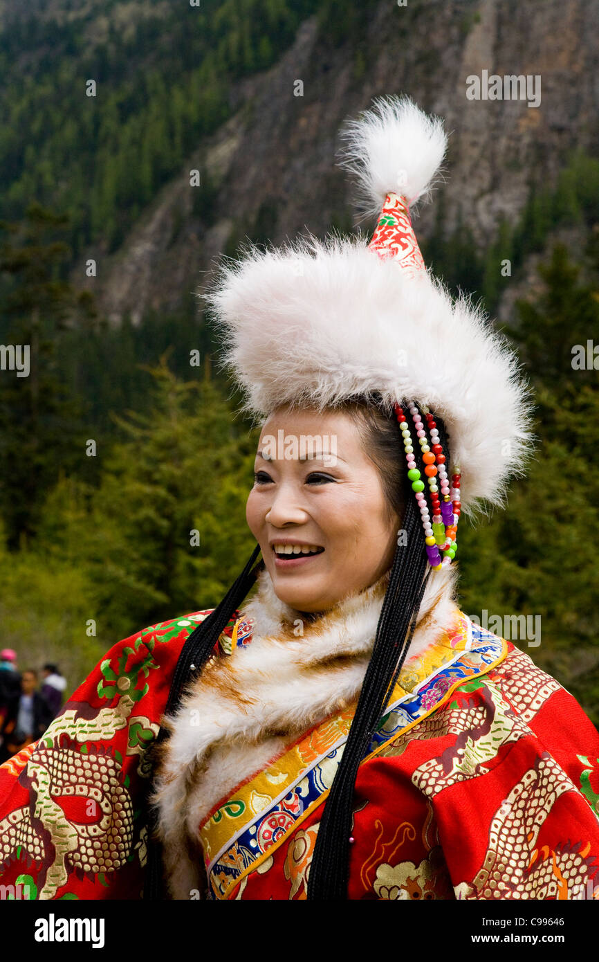 La femme chinoise traditionnelle tibétaine en tourisme costume national /  robe, with fur hat & manches longues. Vallée de Jiuzhaigou, Chine Photo  Stock - Alamy