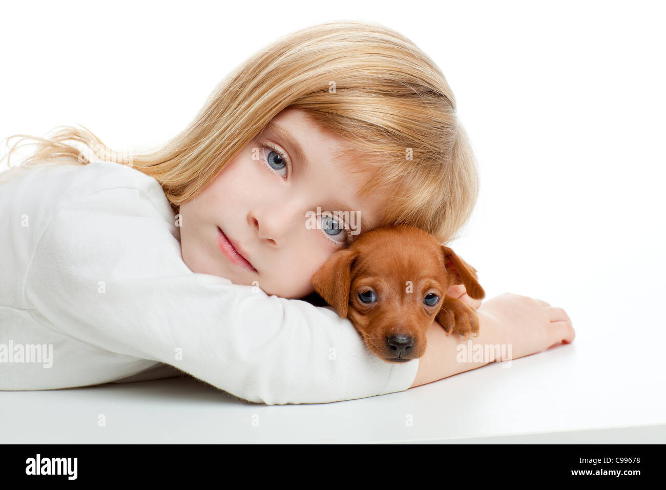 Kid girl blonde avec mini pinscher chien mascotte animal sur fond blanc Banque D'Images