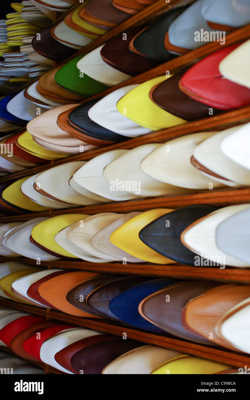 Les hommes marocains colorés silppers alignés sur une étagère à chaussures dans un magasin Banque D'Images