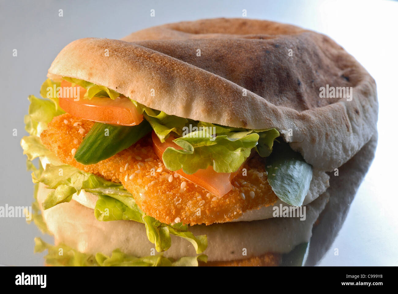 Escalope de poulet panée (schnitzel) dans un pain pita avec de la salade Banque D'Images