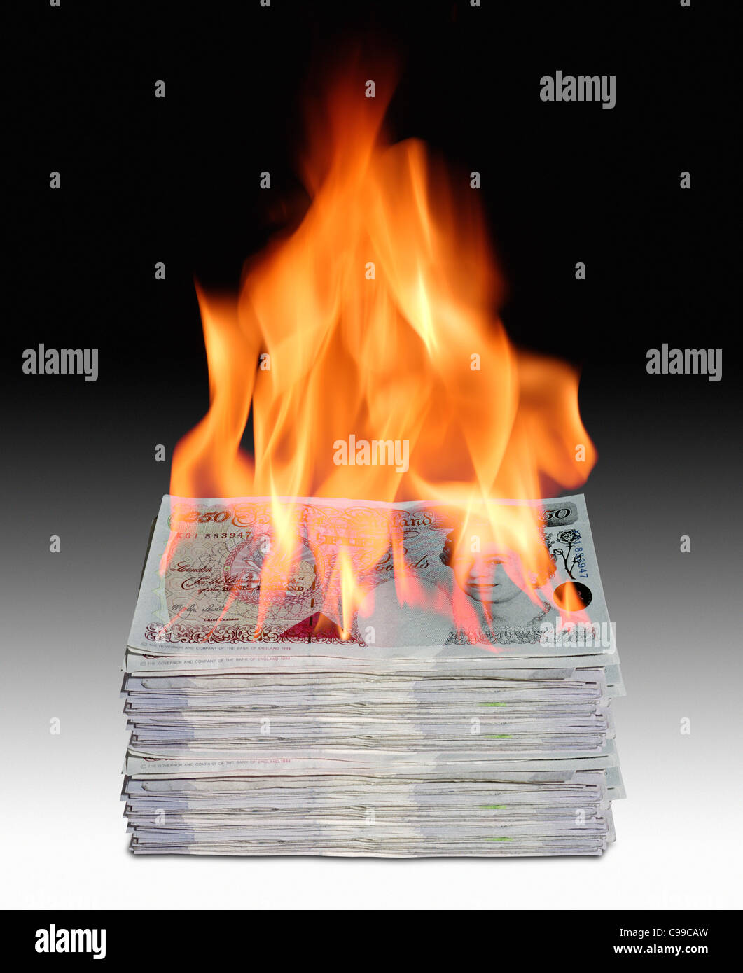 Pile de billets de banque britannique en feu. Banque D'Images
