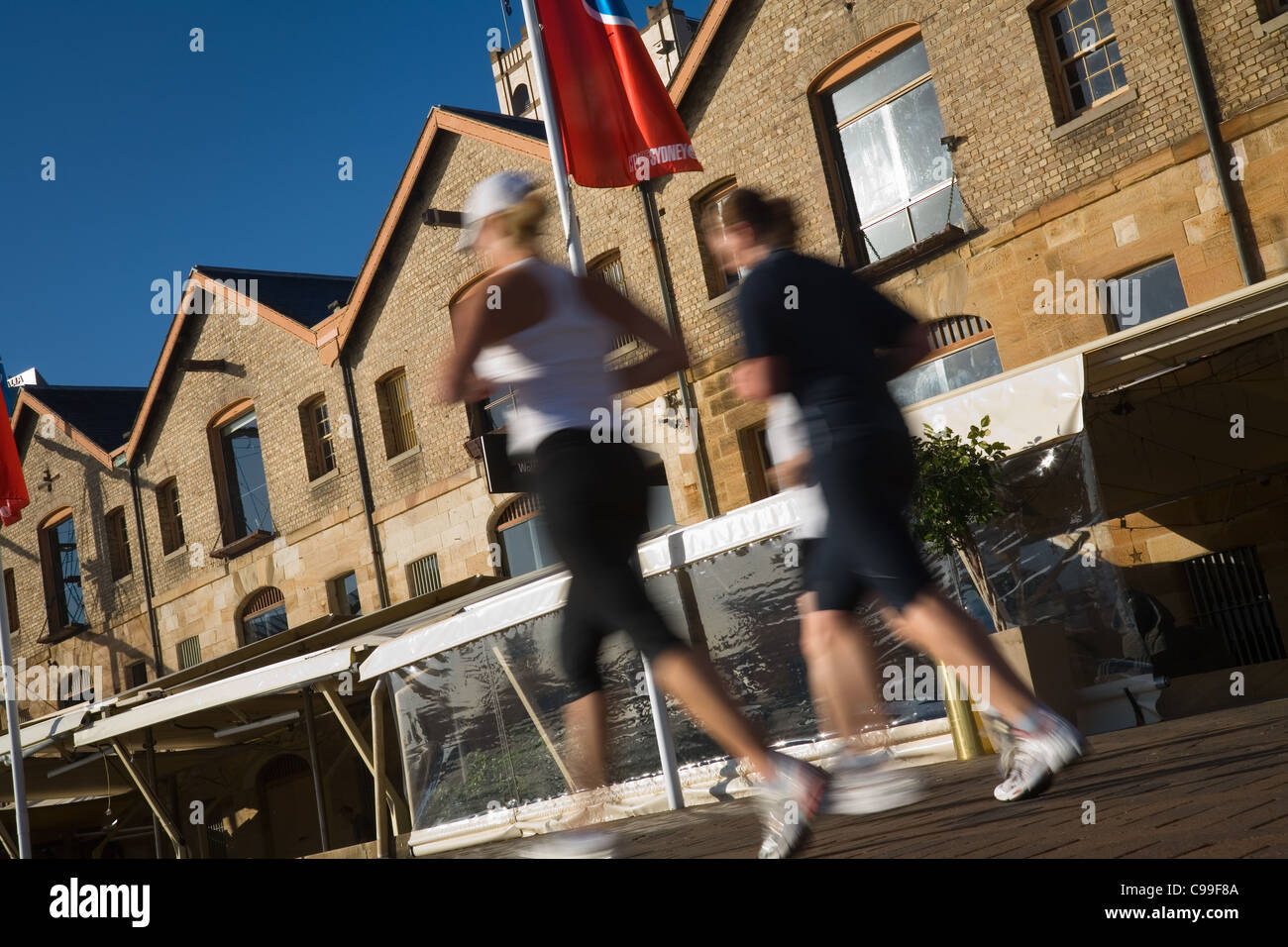 Les joggeurs du matin passer l'architecture historique de Campbell's Cove. The Rocks, Sydney, New South Wales, Australie Banque D'Images