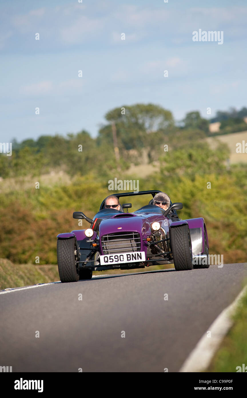 Voiture kit violet traverse l'Angleterre rurale dans l'été. Banque D'Images