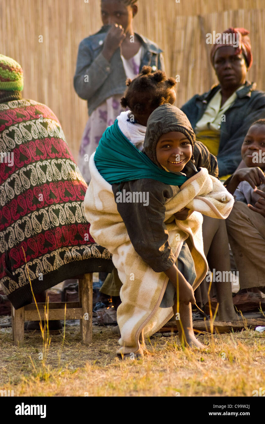 Un garçon transporte sa petite sœur à rassembler des Adventistes du Septième Jour dans l'Est du Caprivi occidental, Namibie. Banque D'Images