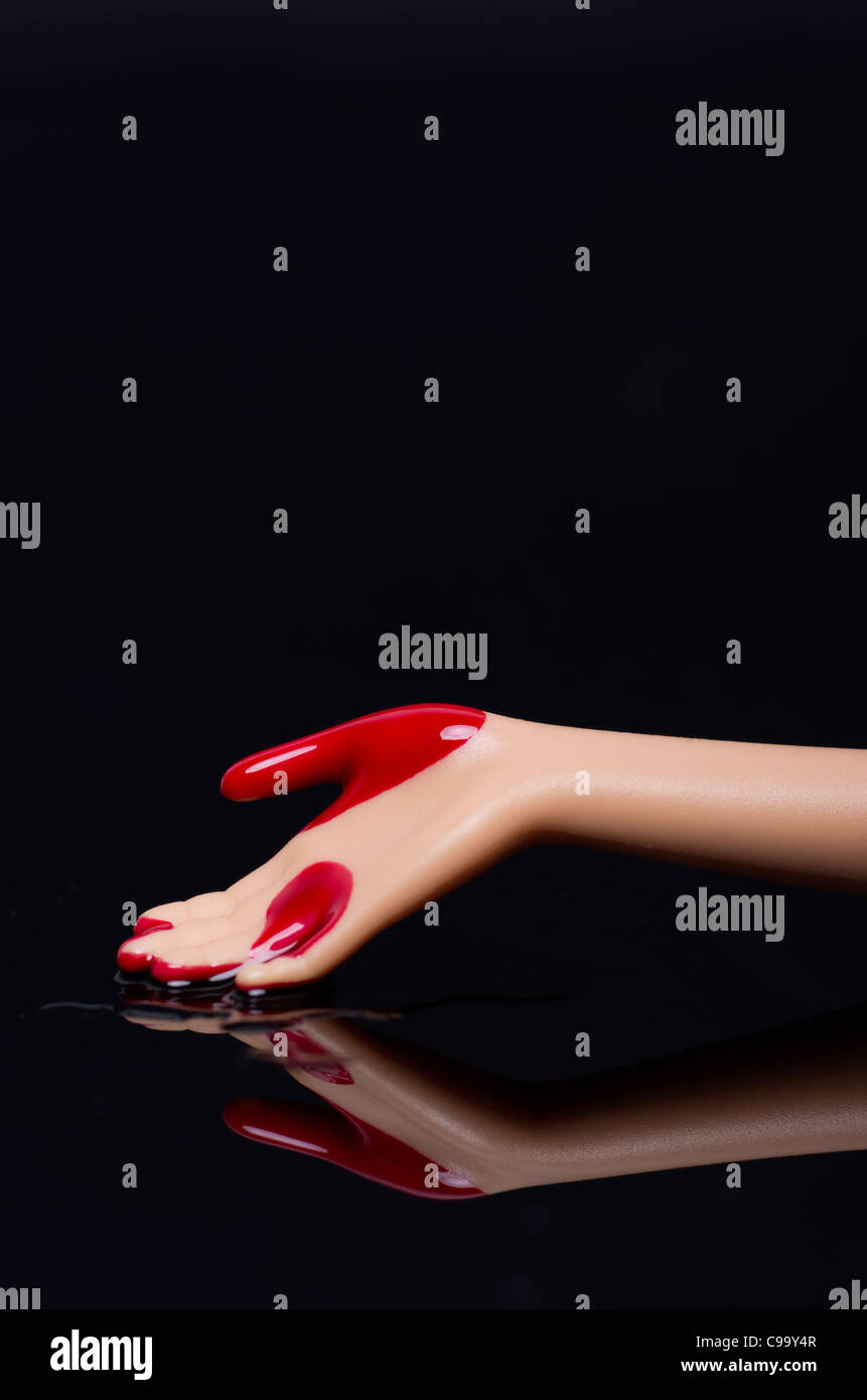 Close up of doll part avec du sang sur fond noir Banque D'Images