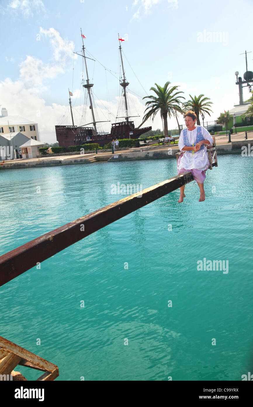 Une femme est condamnée à la 'Le tabouret Dunk', comme un 'nag et les potins ' dans une reconstitution historique à Saint-Georges, les Bermudes Banque D'Images