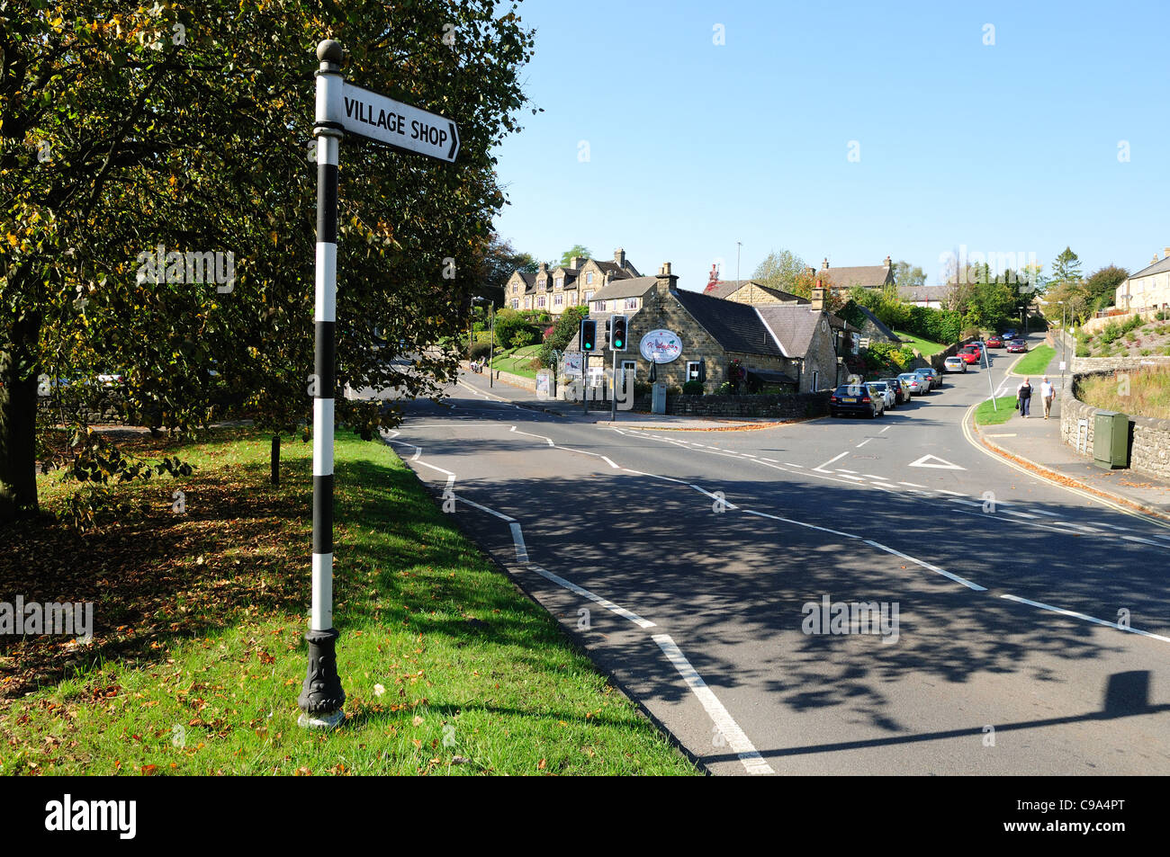 Village Buxton et signer par un fort trafic sur route principale. Banque D'Images