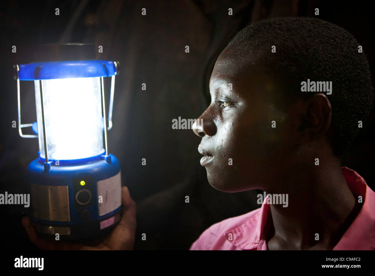 Saumu a une lumière solaire monté dans sa chambre pour l'aider à étudier. Une ONG Wema a fourni environ 100 lumières solaires aux étudiants. Banque D'Images