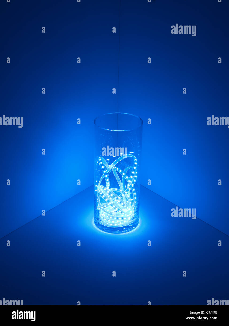 Voyant bleu indique dans un vase de verre dans une salle sombre Banque D'Images