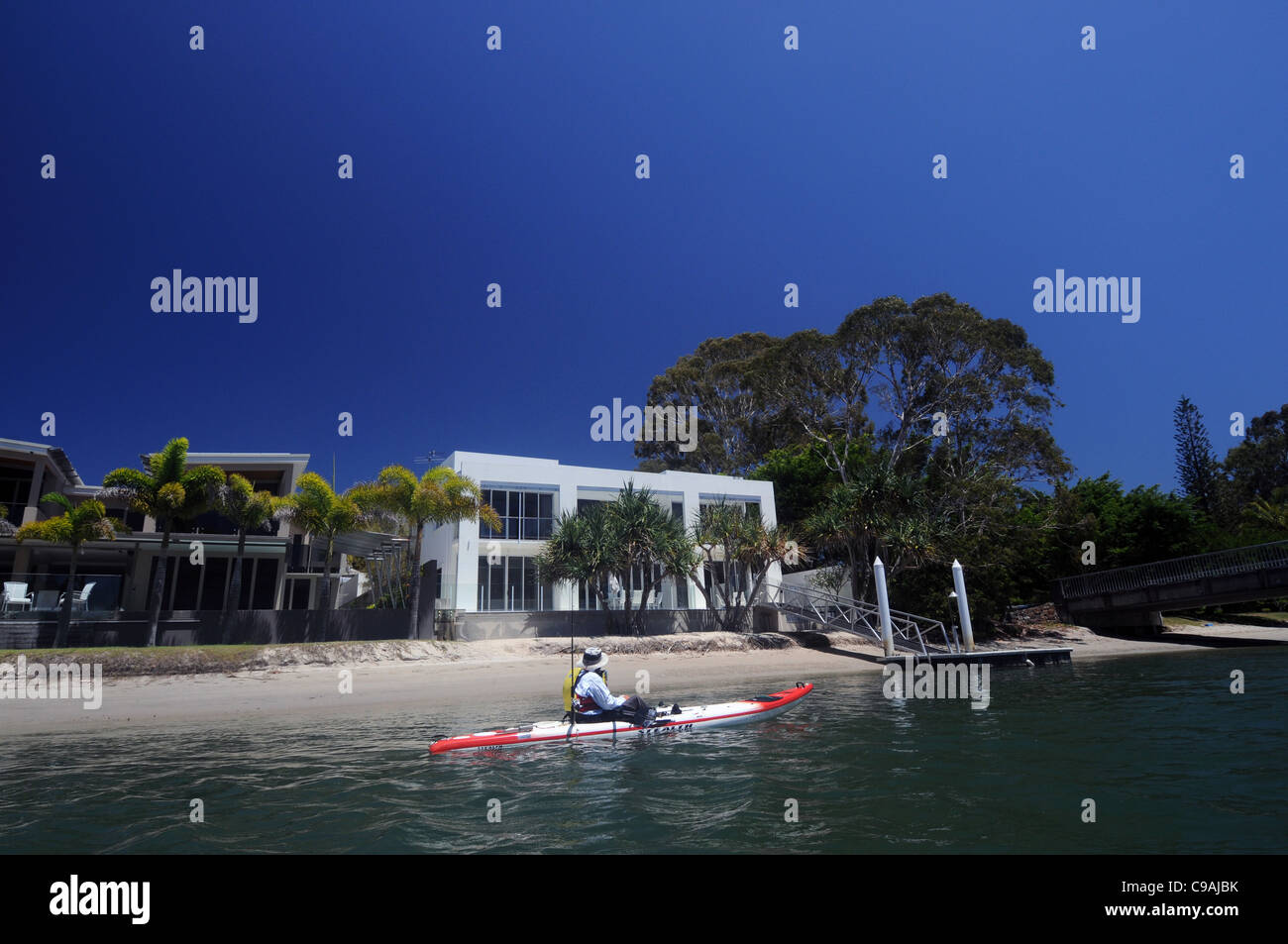 Que vous recherchiez un kayakiste en passant par des maisons dans votre canal à Noosa, Sunshine Coast, Queensland, Australie. Pas de monsieur ou PR Banque D'Images