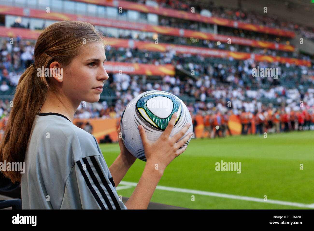 Une balle girl détient un ballon de match officiel à l'édition 2011 de la Coupe du Monde féminine de la FIFA, un match de groupe entre la France et l'Allemagne. Banque D'Images