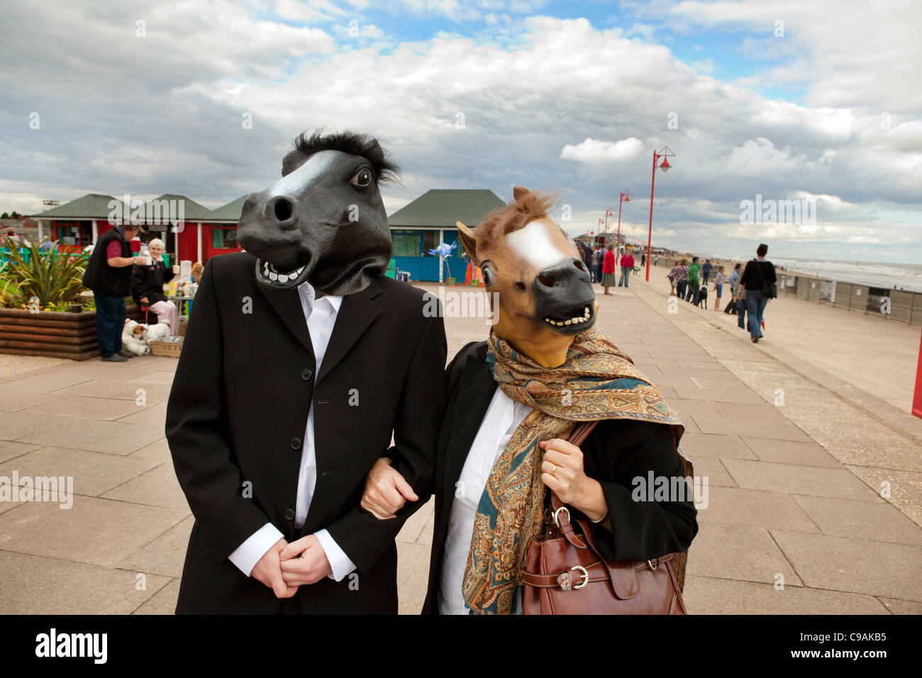 Deux acteurs portant des têtes de chevaux le long du front de mer à Mablethorpe, au Royaume-Uni, au cours de l'baigneuses beach hut festival Banque D'Images