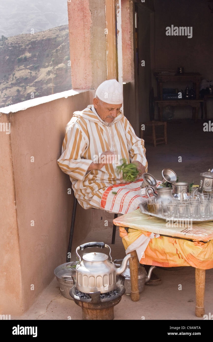 Un homme Berbère marocain et de faire préparer un thé à la menthe marocain à sa maison dans les montagnes de l'Atlas Maroc Afrique du Nord Banque D'Images