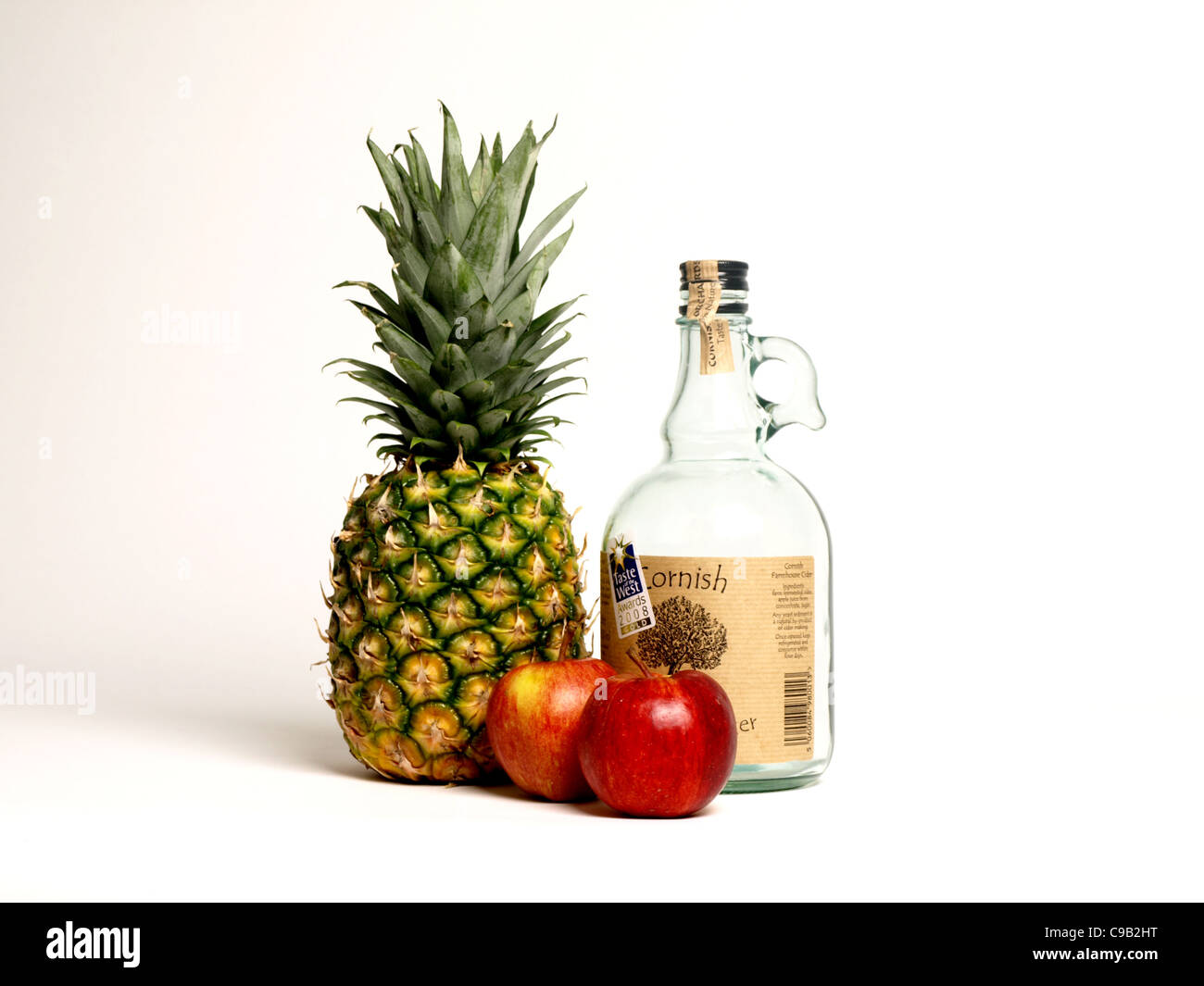 La vie encore d'ananas, de pommes et une bouteille vide de cidre Banque D'Images