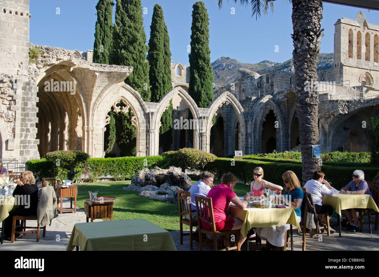 Vue montrant les arches gothiques de l'abbaye de Bellapais Bellais, village, Chypre du Nord avec les personnes coin Banque D'Images