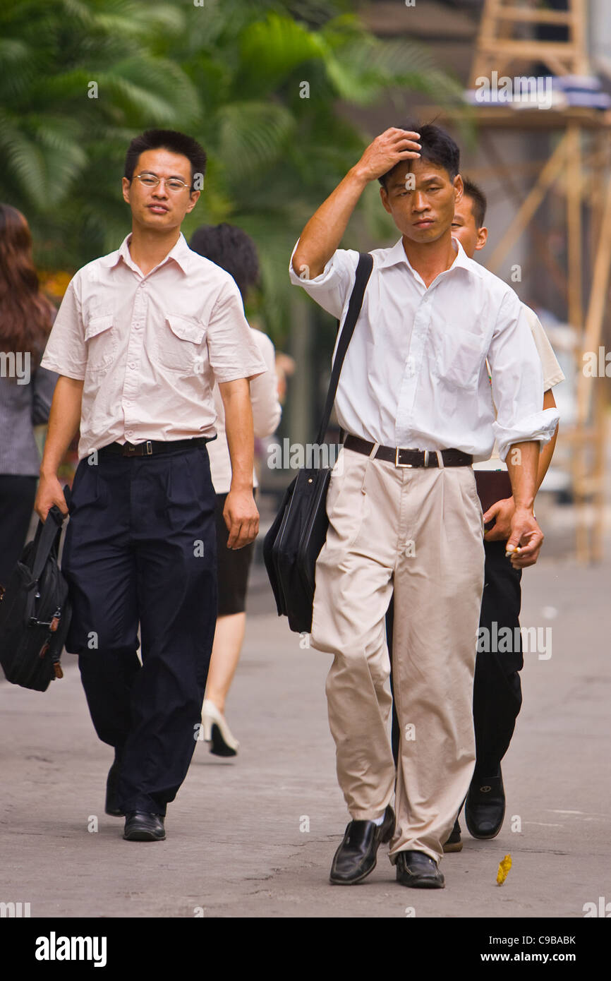 GUANGZHOU, province de Guangdong, Chine - hommes marchant sur le trottoir, dans la ville de Guangzhou. Banque D'Images