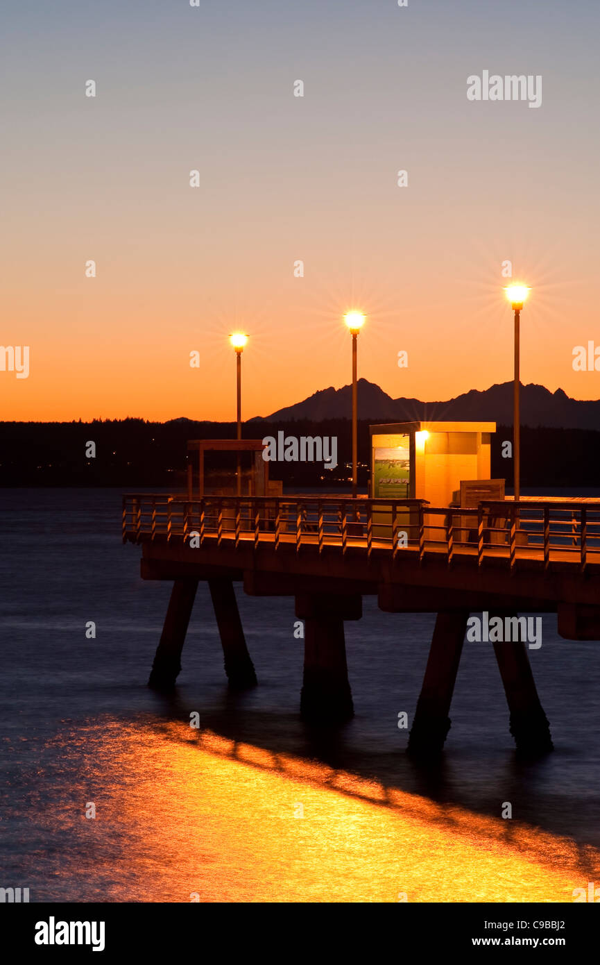 La silhouette du pier avec les gens la pêche au large de dock au coucher du soleil sur le Puget Sound avec montagnes Olympiques Edmonds, Washington State USA Banque D'Images