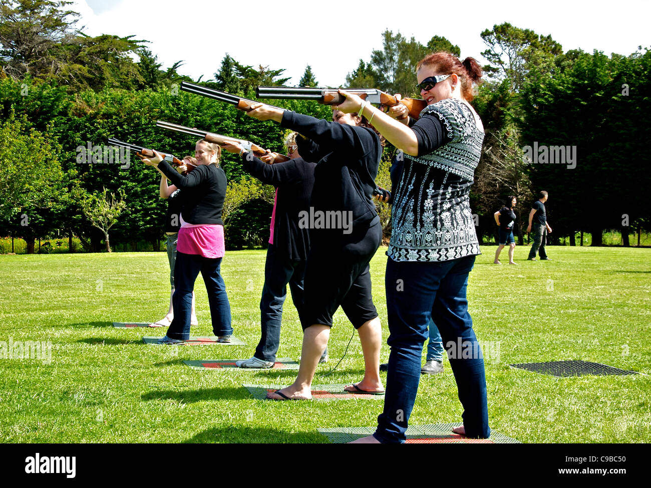 Équipe de femmes participant à une partie amicale de tir au pigeon laser à l'état sauvage sur des motifs vignoble Waiheke Banque D'Images