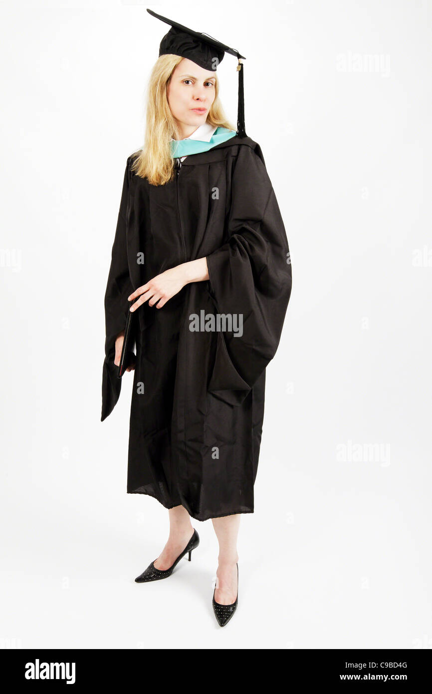 Jeune femme vêtue Um dans une graduation Gown Holding un diplôme d'études secondaires Banque D'Images