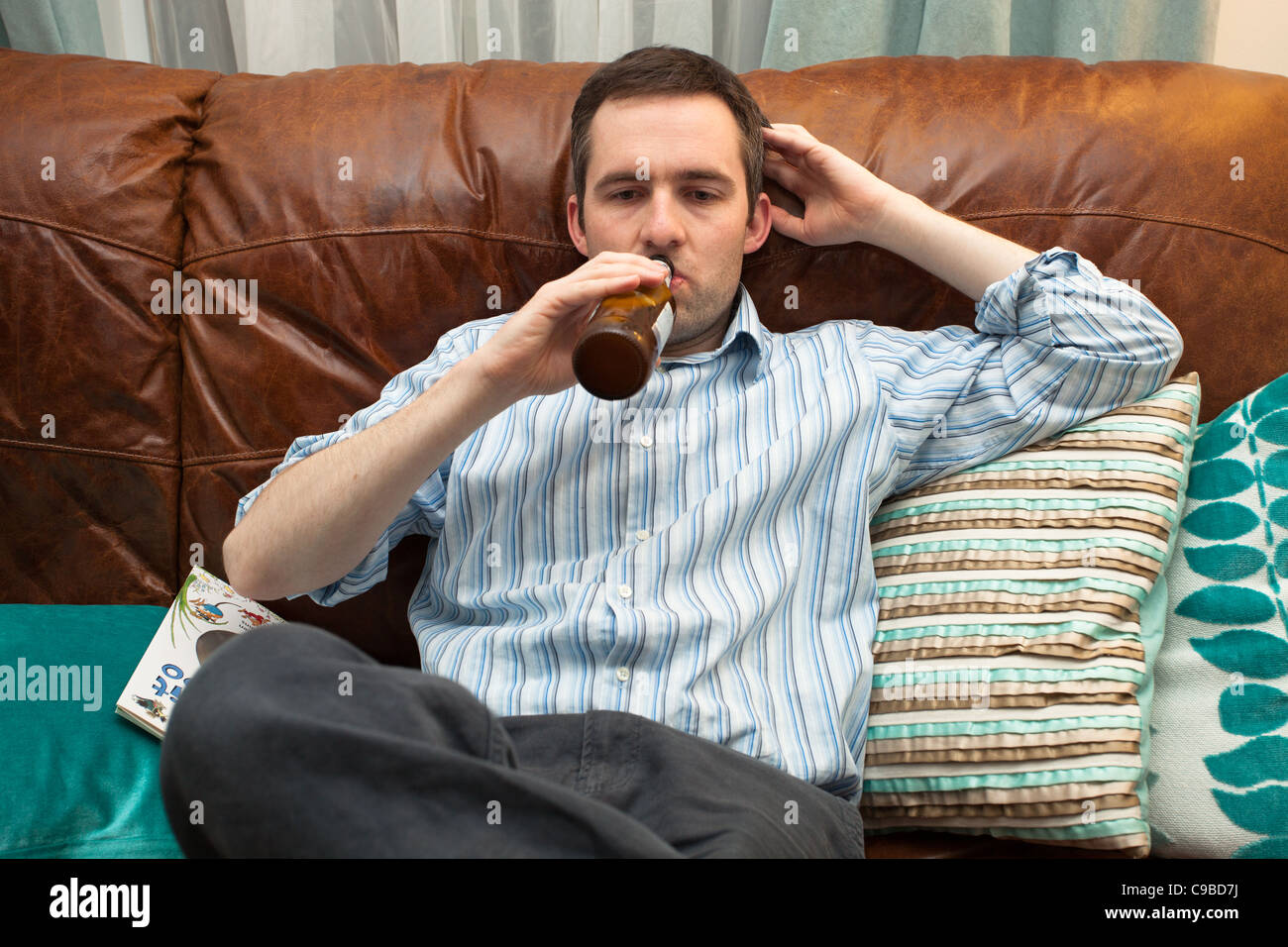 Jeune homme professionnel de boire de bière sans alcool/lager Banque D'Images