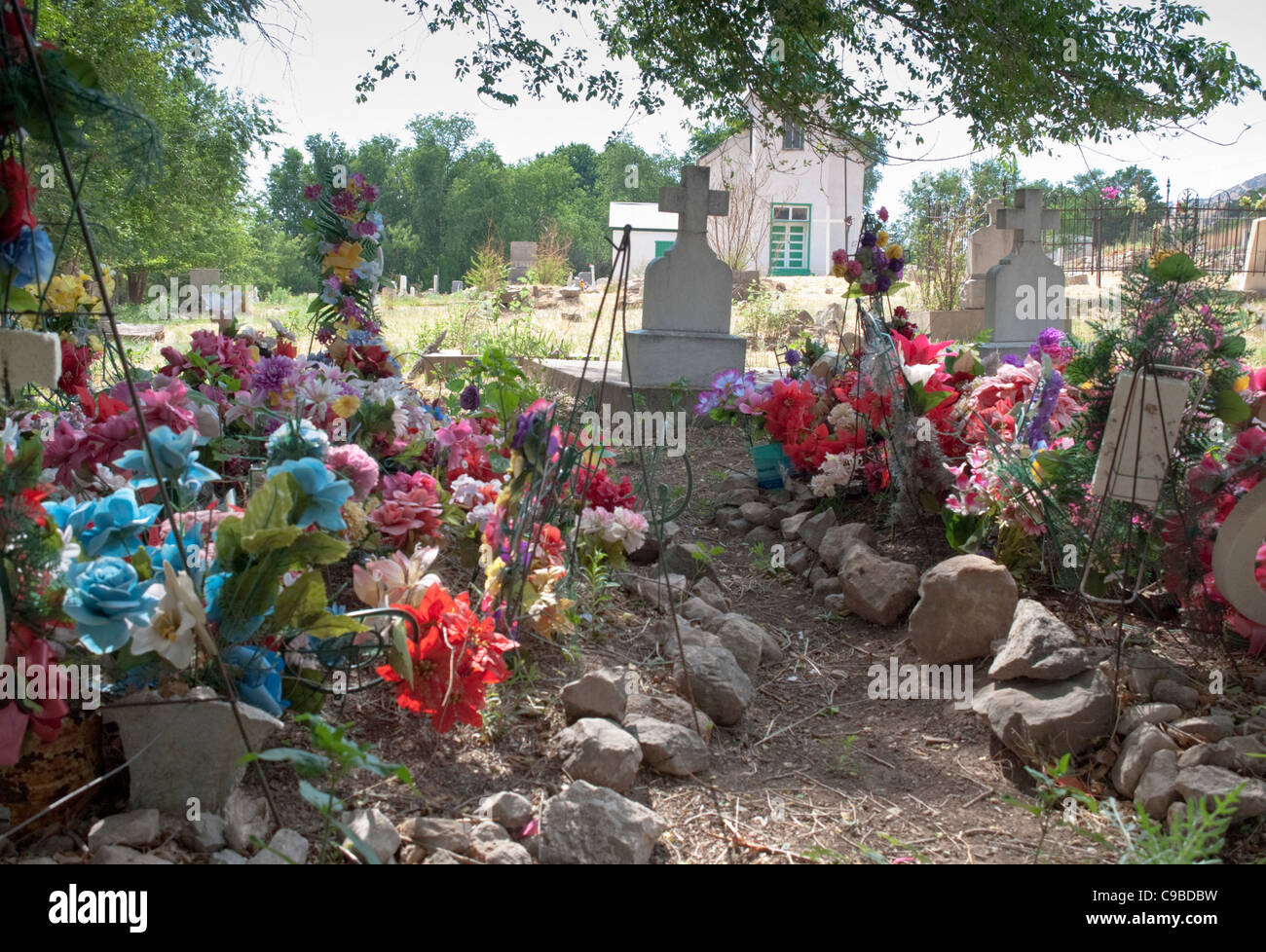 Le cimetière à l'intérieur de l'église de triage à San Patricio est parsemé de fleurs en plastique de couleur vive. Banque D'Images