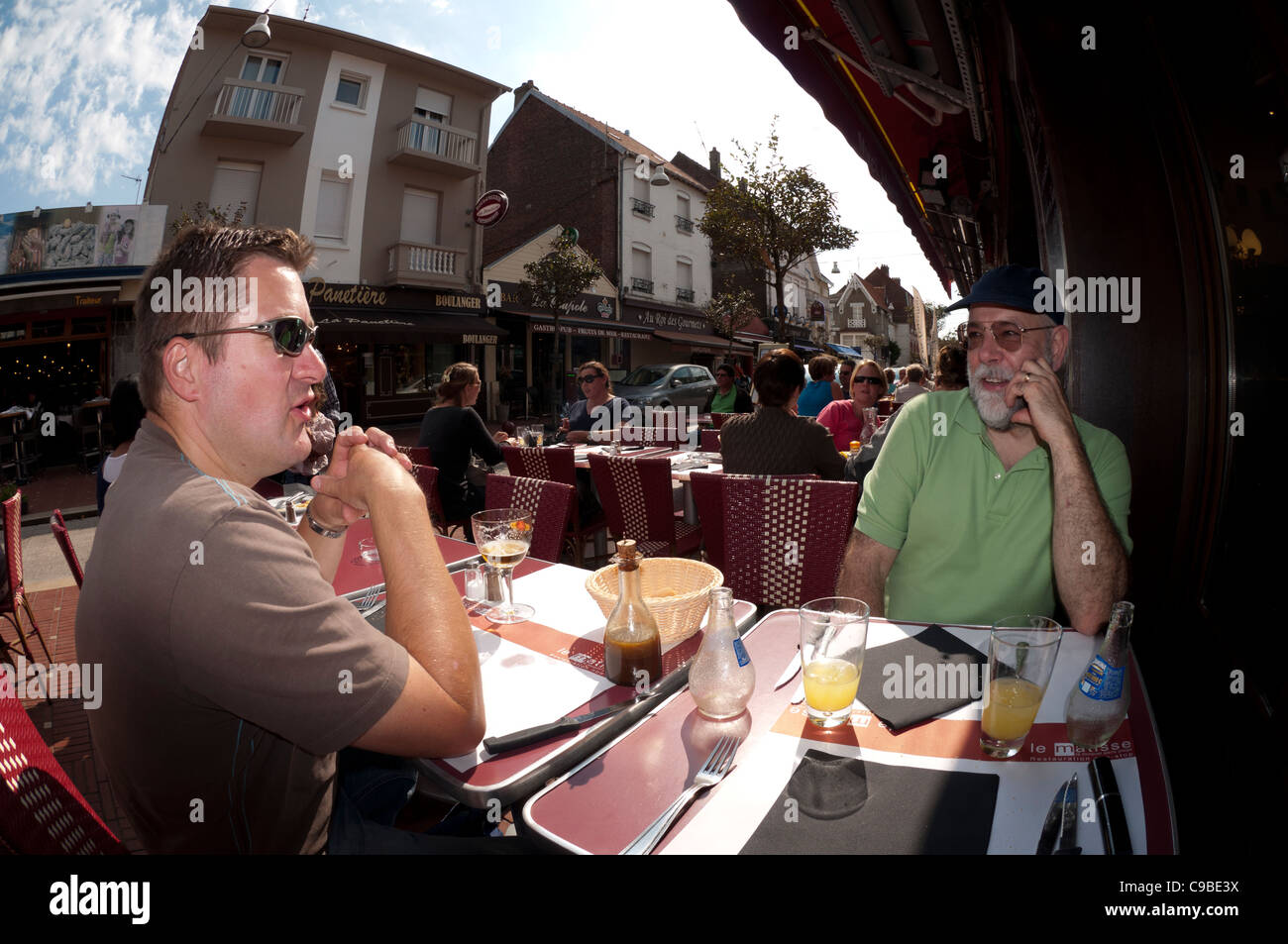 Les gens assis se détendre boire et manger dans un café de la rue chaussée français extérieur à Le touquet France Banque D'Images