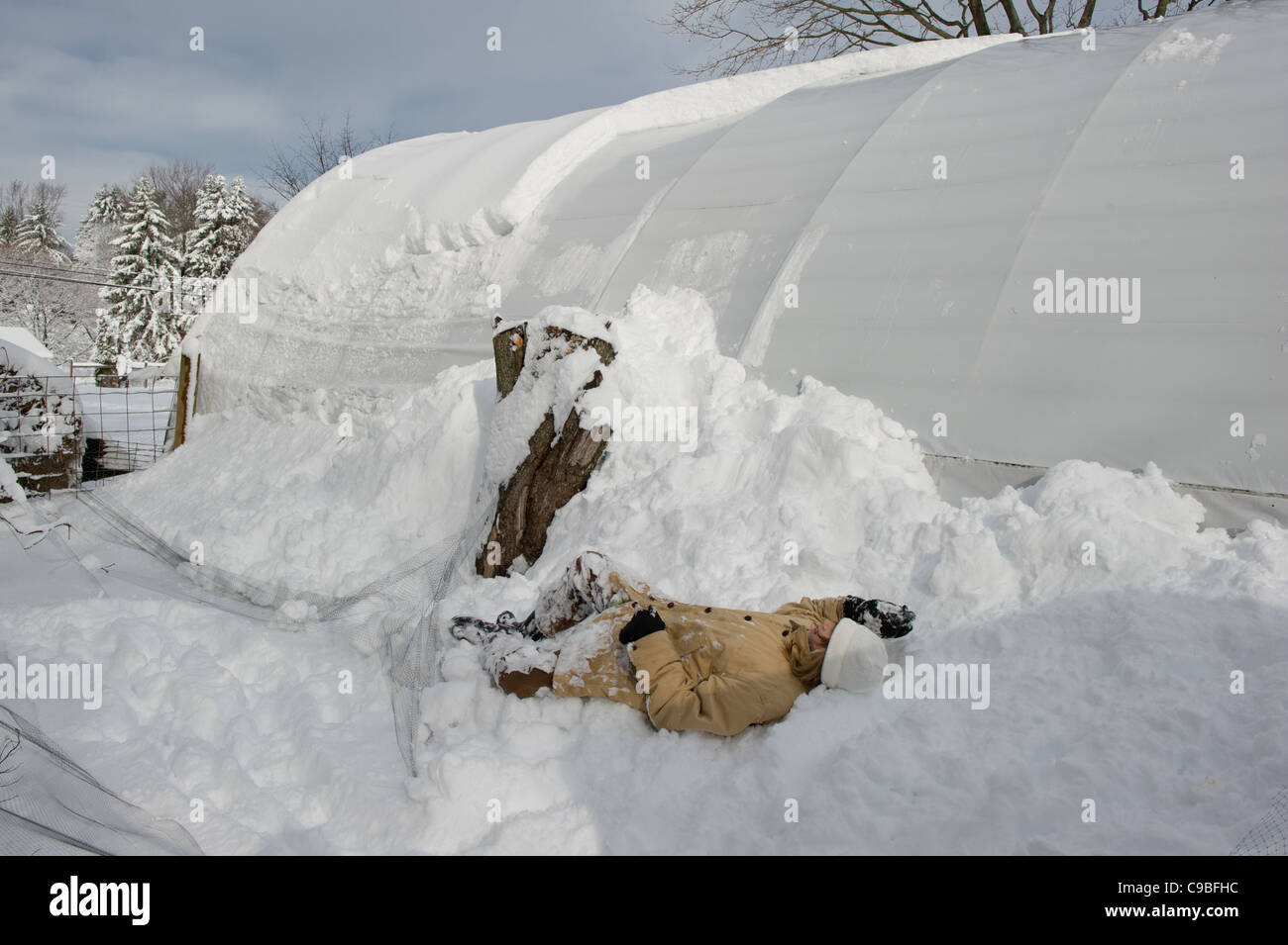 Pose de fille dans la neige sur une ferme Banque D'Images