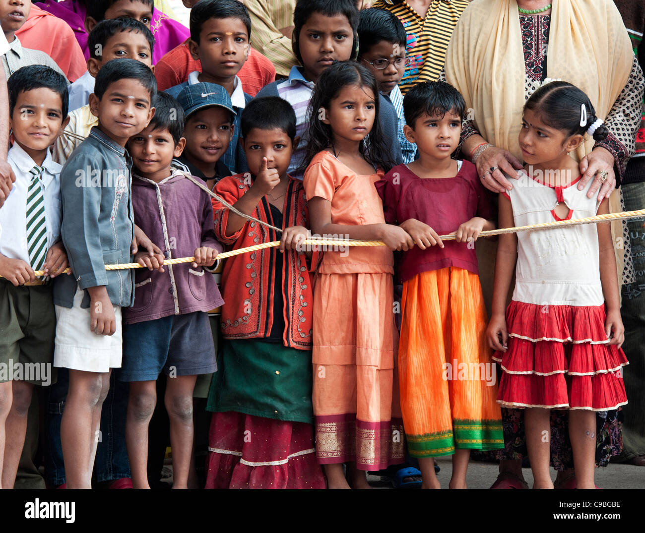 Les enfants indiens derrière la corde dans la rue, sur un jour de festival. L'Andhra Pradesh, Inde Banque D'Images