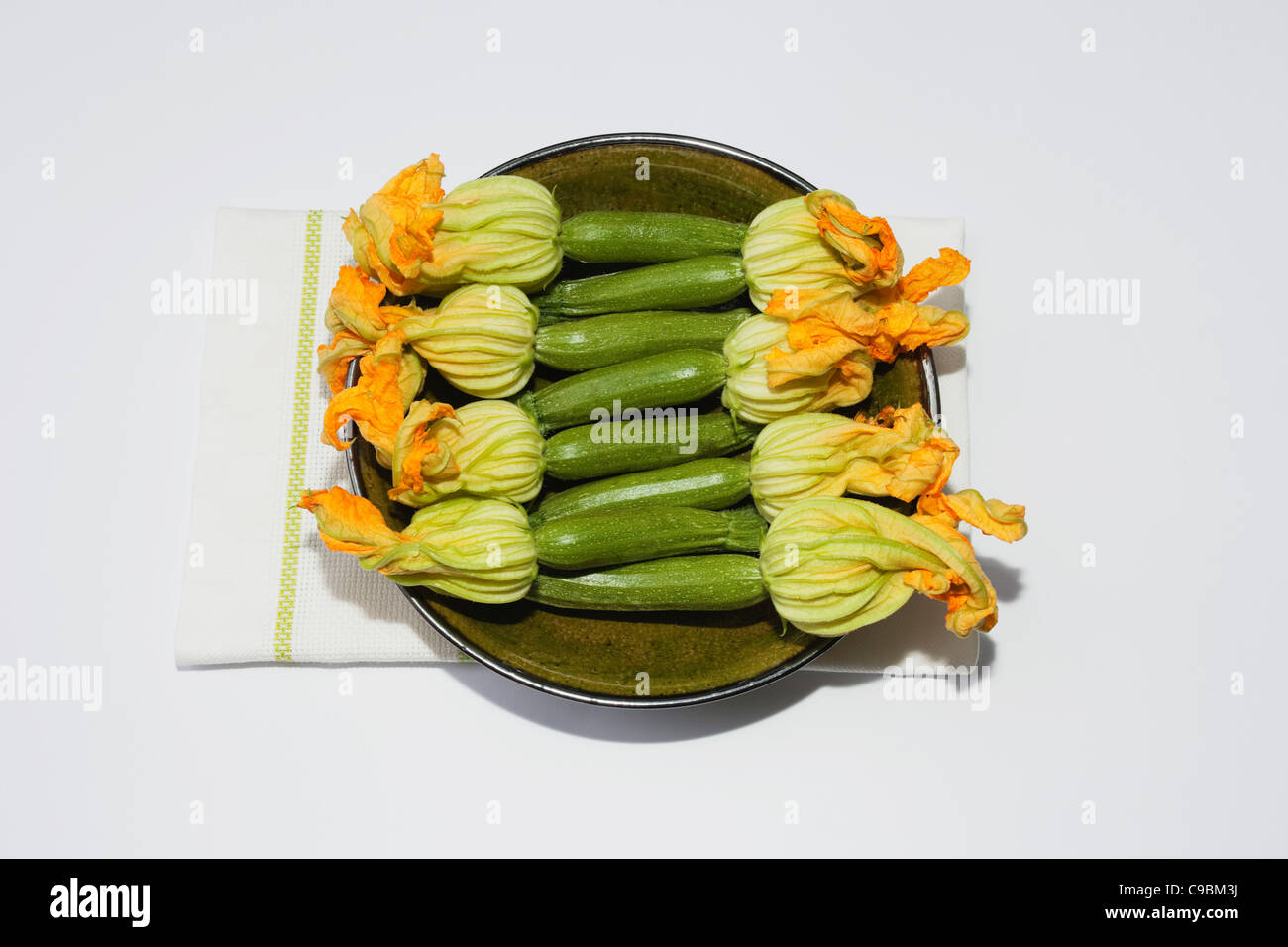 Avec des fleurs de courgettes en plaque en céramique sur un torchon, Close up Banque D'Images
