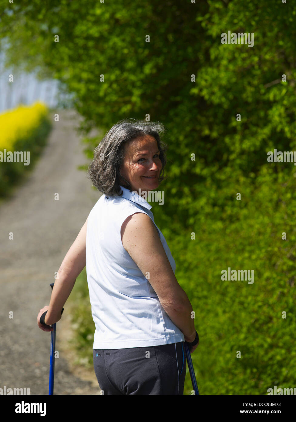 Allemagne, mature woman nordic walking, smiling, portrait Banque D'Images