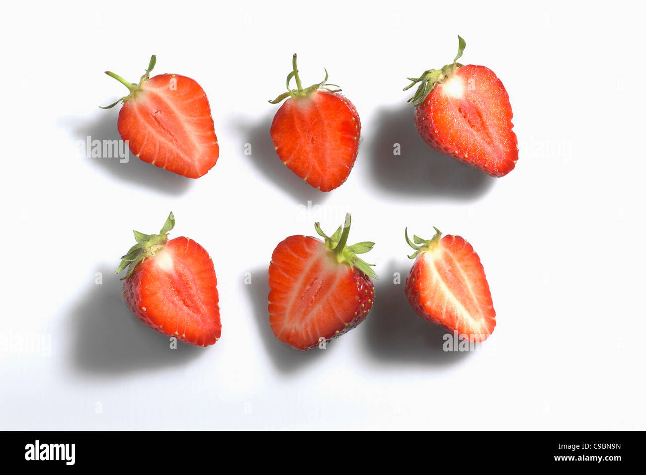 Couper la moitié des fraises sur fond blanc Banque D'Images