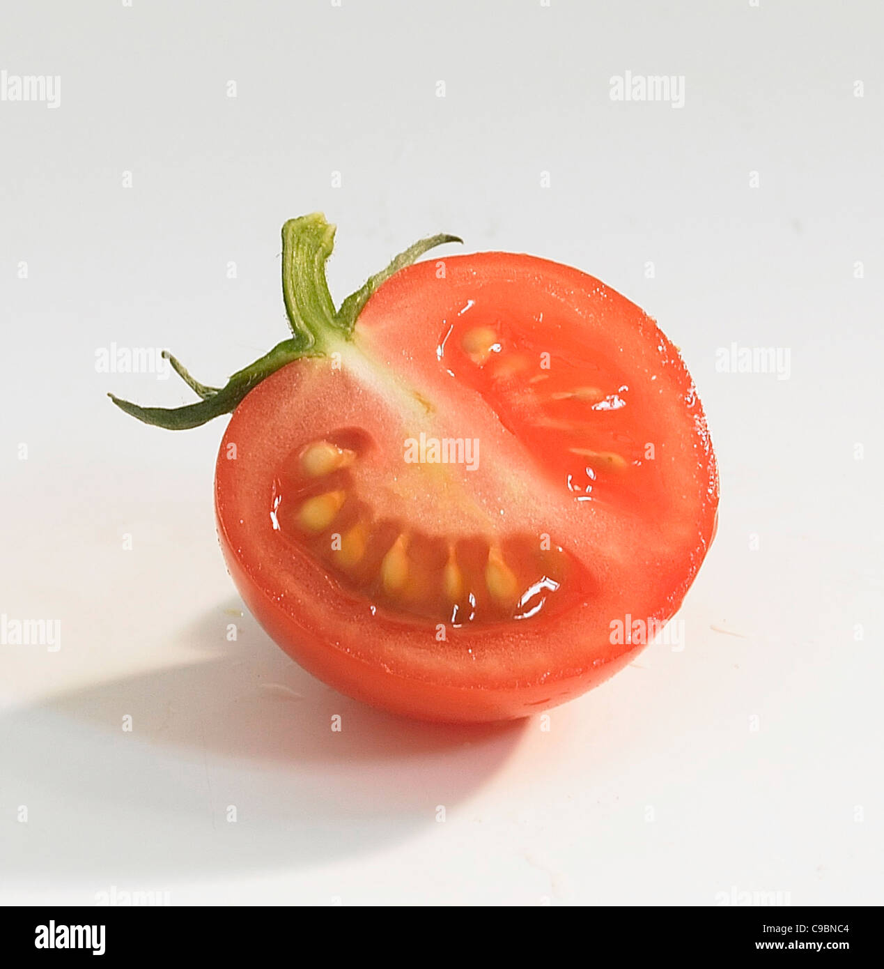 Tranche de tomate sur fond blanc Banque D'Images