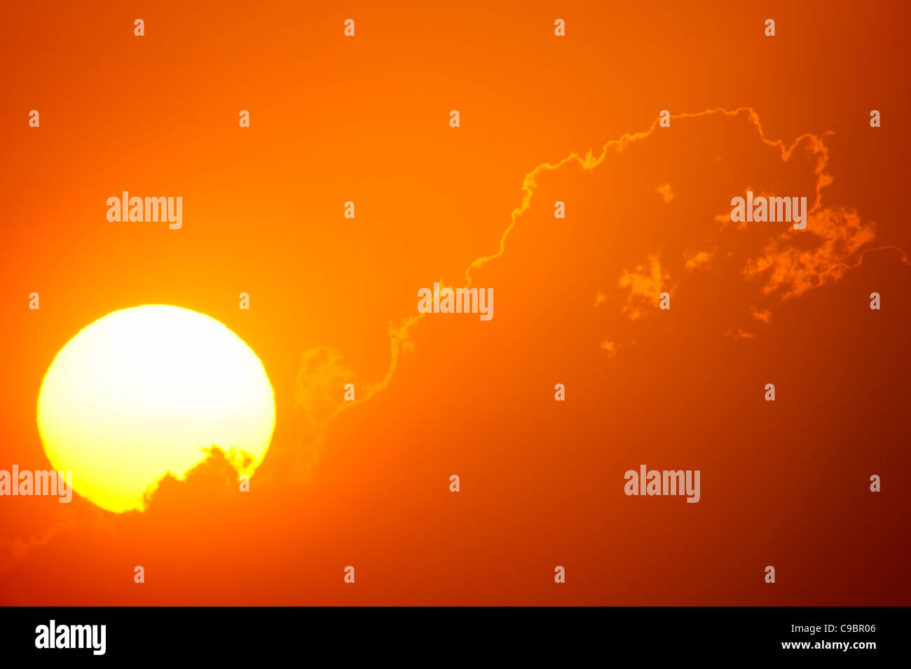 Vue téléobjectif du soleil levant derrière nuages orange, Durban, Kwazulu-Natal, Afrique du Sud Banque D'Images