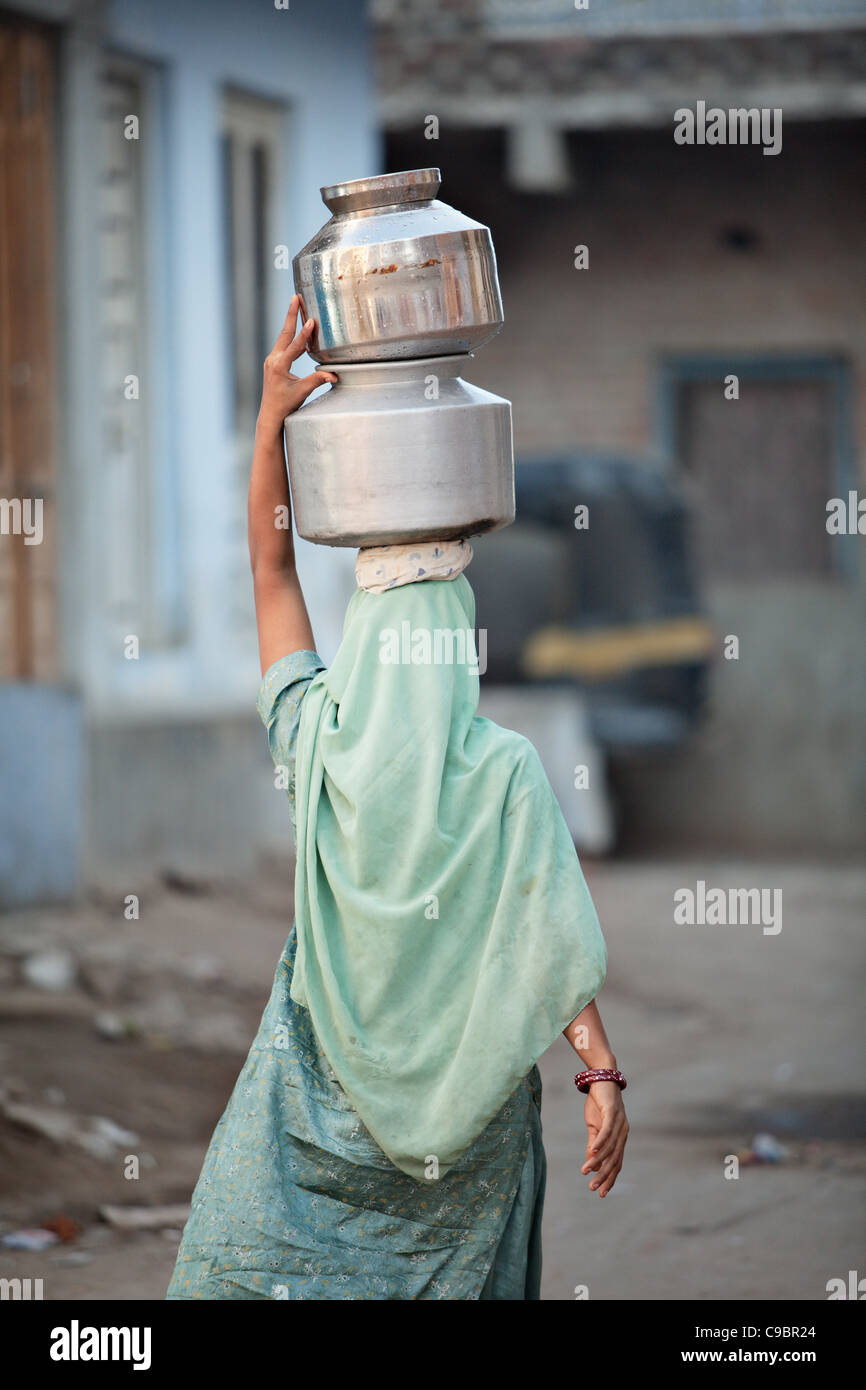 Femme musulmane portant de l'eau dans le village de Sarod, état du