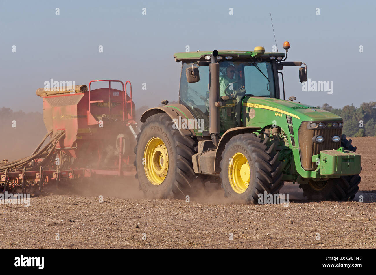John Deere 8345R tracteur avec semoir Vaderstad couture l'orge d'hiver sur les terres sèches et poussiéreuses, Sutton, Suffolk, UK. Banque D'Images