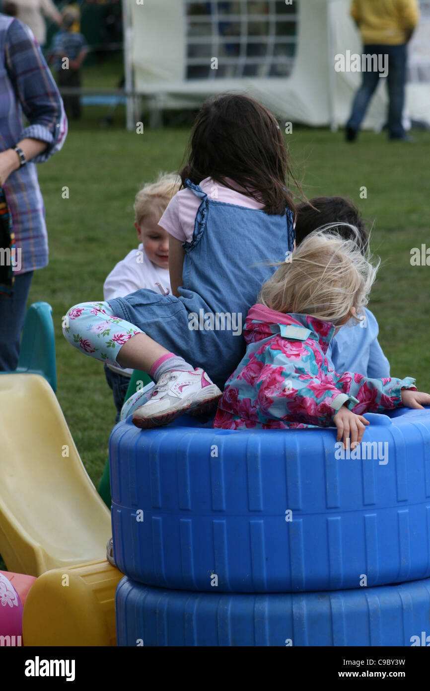 Les jeunes enfants à jouer dans des bacs de plastique à village équitable. Banque D'Images