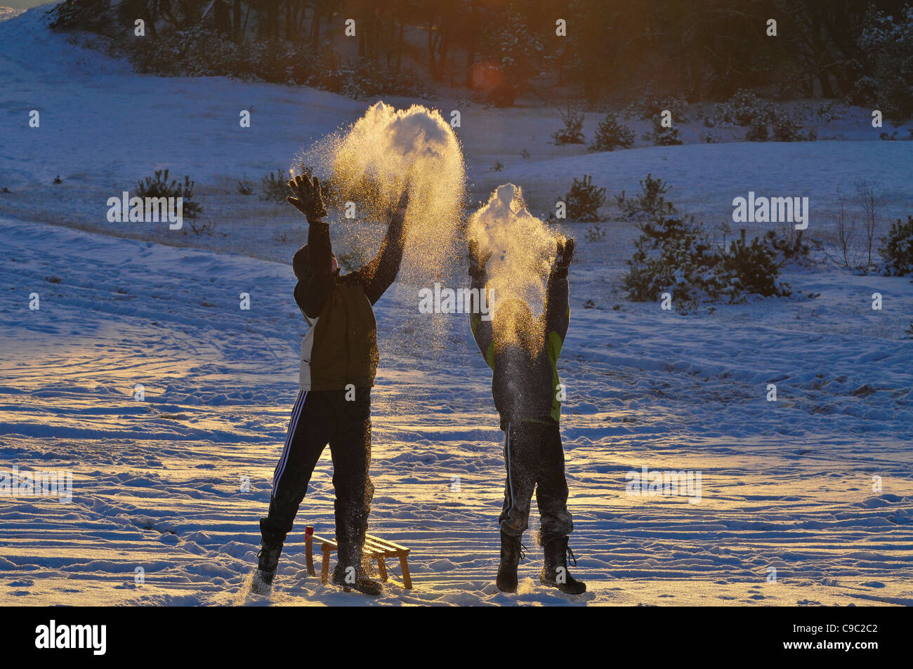 Garçon jouant et jeter de la neige dans l'air Banque D'Images