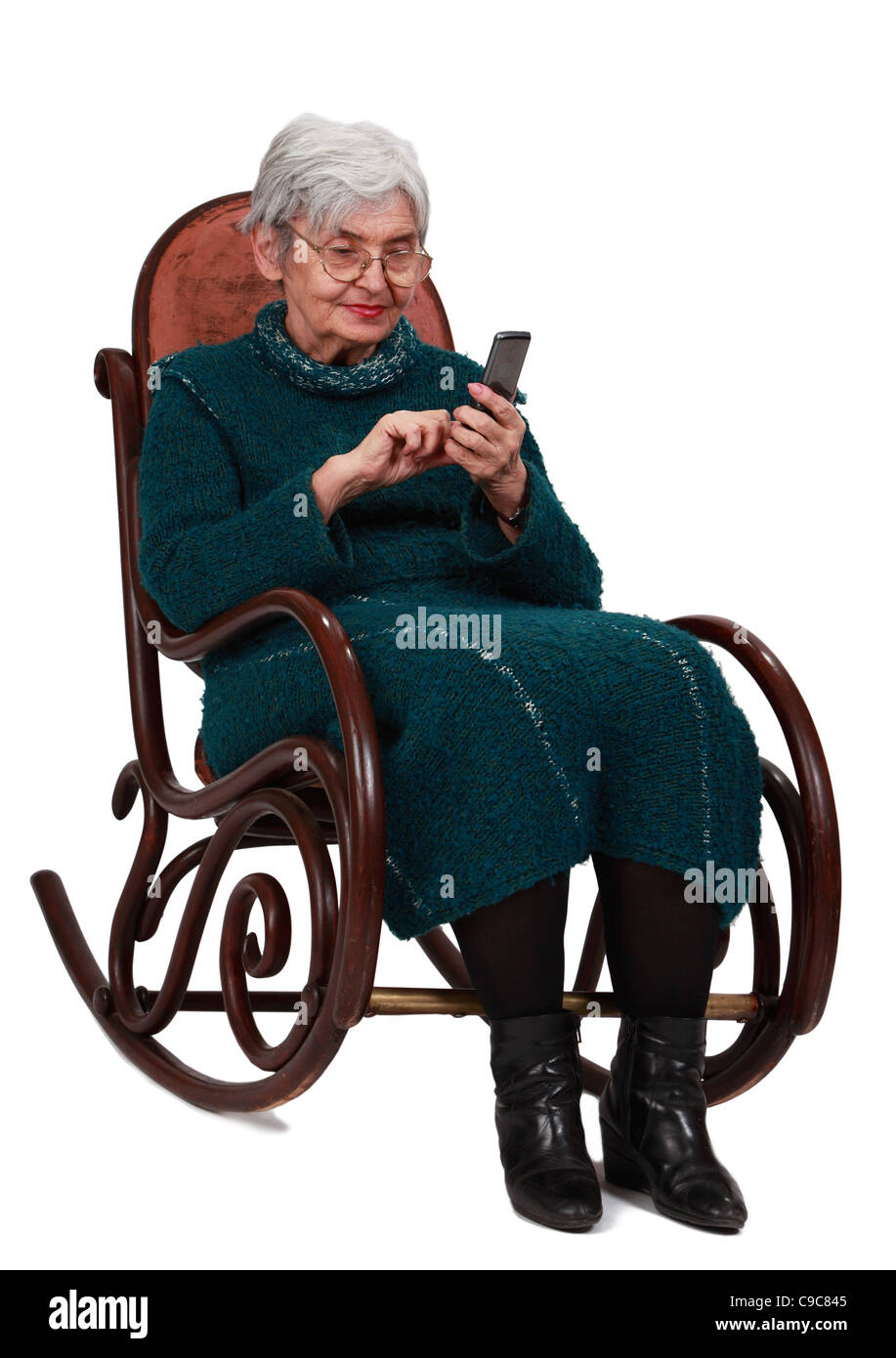 Image d'une femme senior de l'emplacement dans un fauteuil à bascule et l'écriture d'un message téléphonique. Banque D'Images