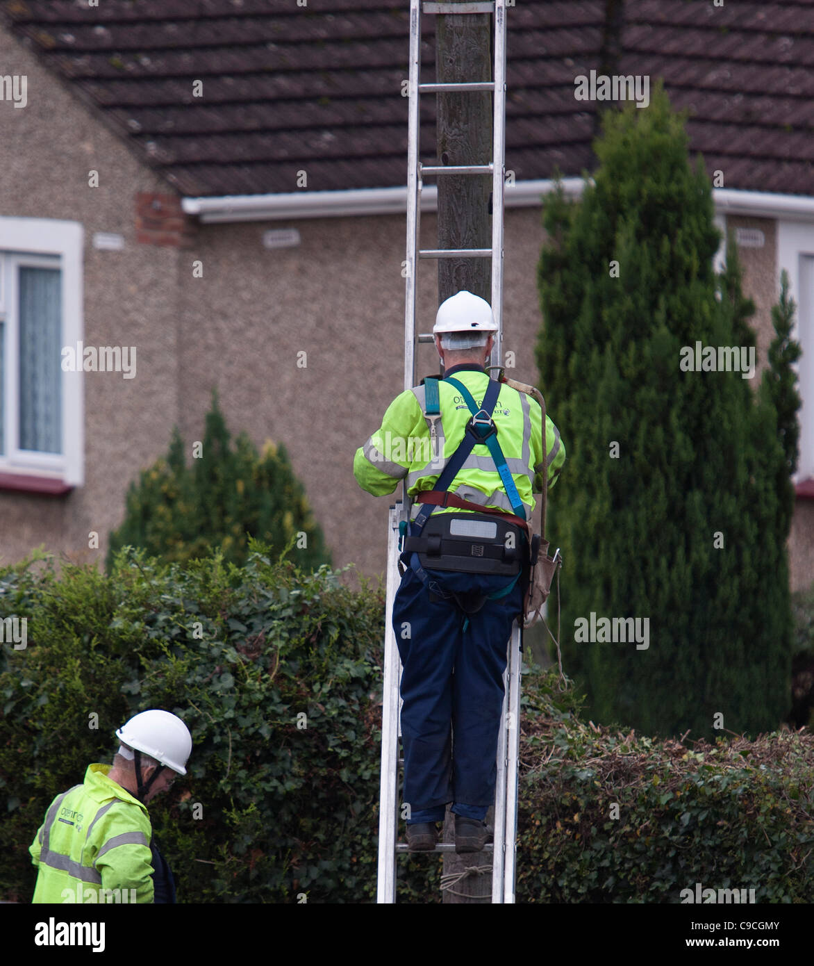 Un BT (British Telecom ingénieur ) grimpe un poteau télégraphique pour effectuer des vérifications de maintenance. Banque D'Images