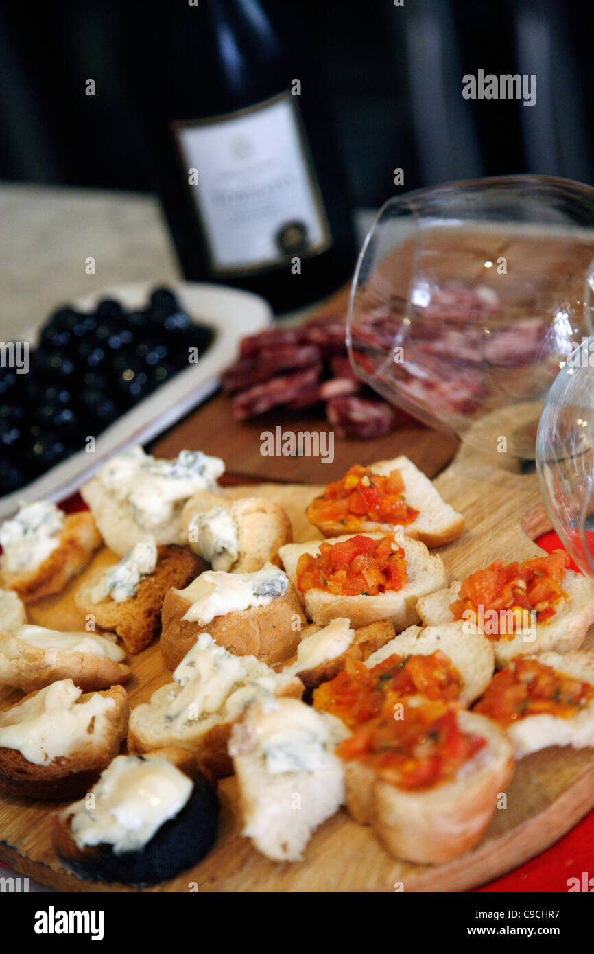 Assiette de fromage, salami, des olives et du vin à l'Osteria Da Lio, La Maddalena, en Sardaigne, Italie. Banque D'Images