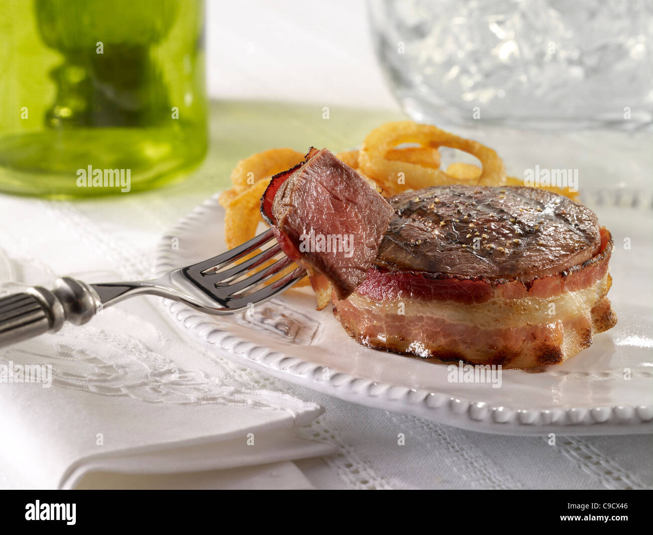 Filet de boeuf enrobé de bacon et servi avec des rondelles d'oignon Banque D'Images