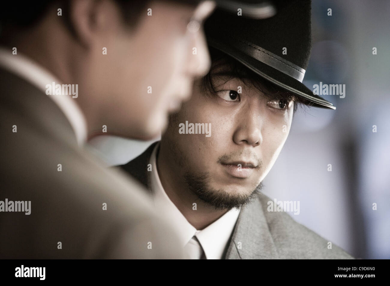 Portrait de deux jeunes hommes asiatiques portant des costumes et chapeaux Banque D'Images