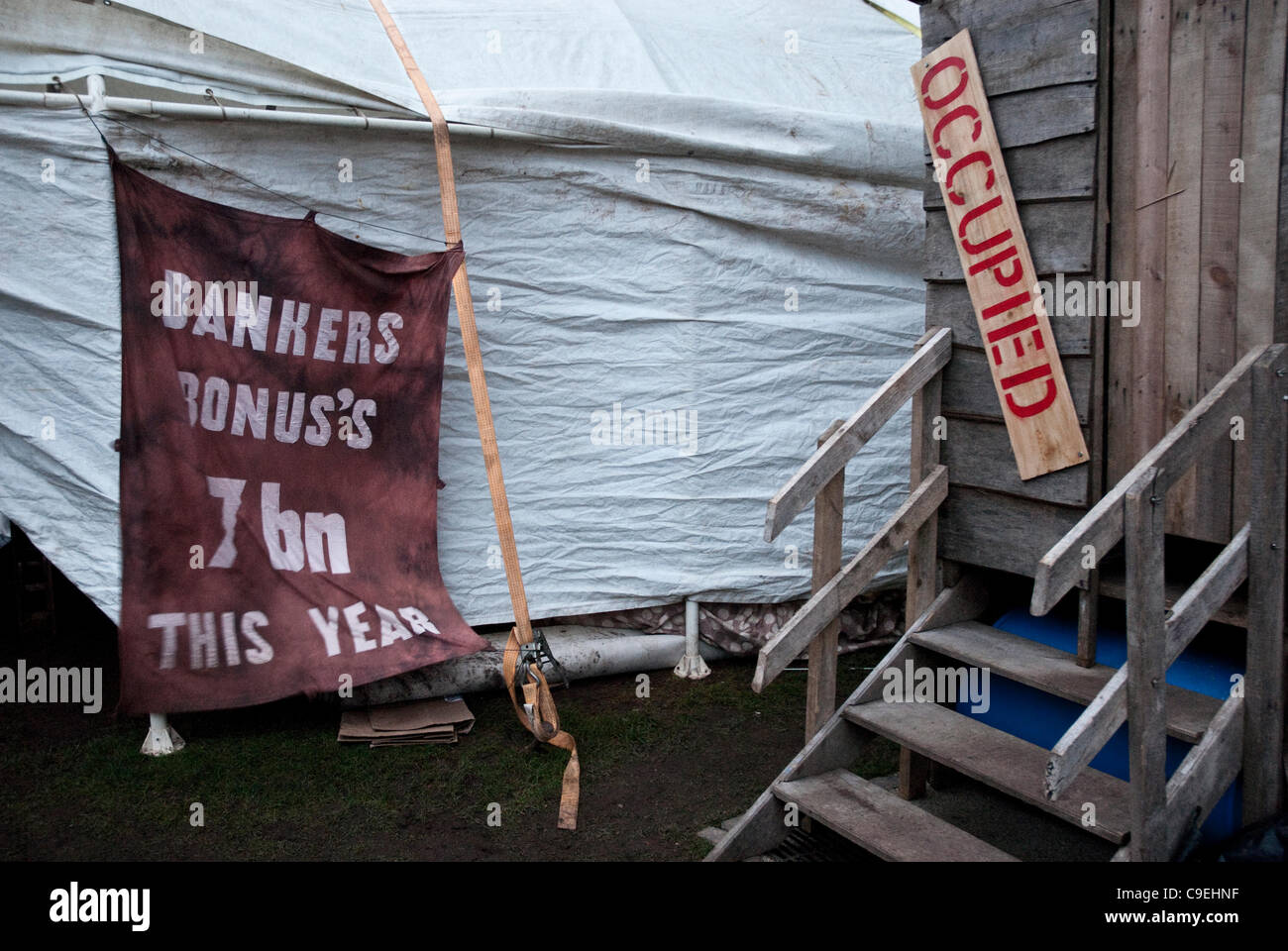 Les nouvelles toilettes et une bannière indiquant "bonus des banquiers 7 milliards cette année" à l'occuper le Camp sur Exeter Exeter Cathédrale vert. Exeter, Devon 08/12/2011 Banque D'Images